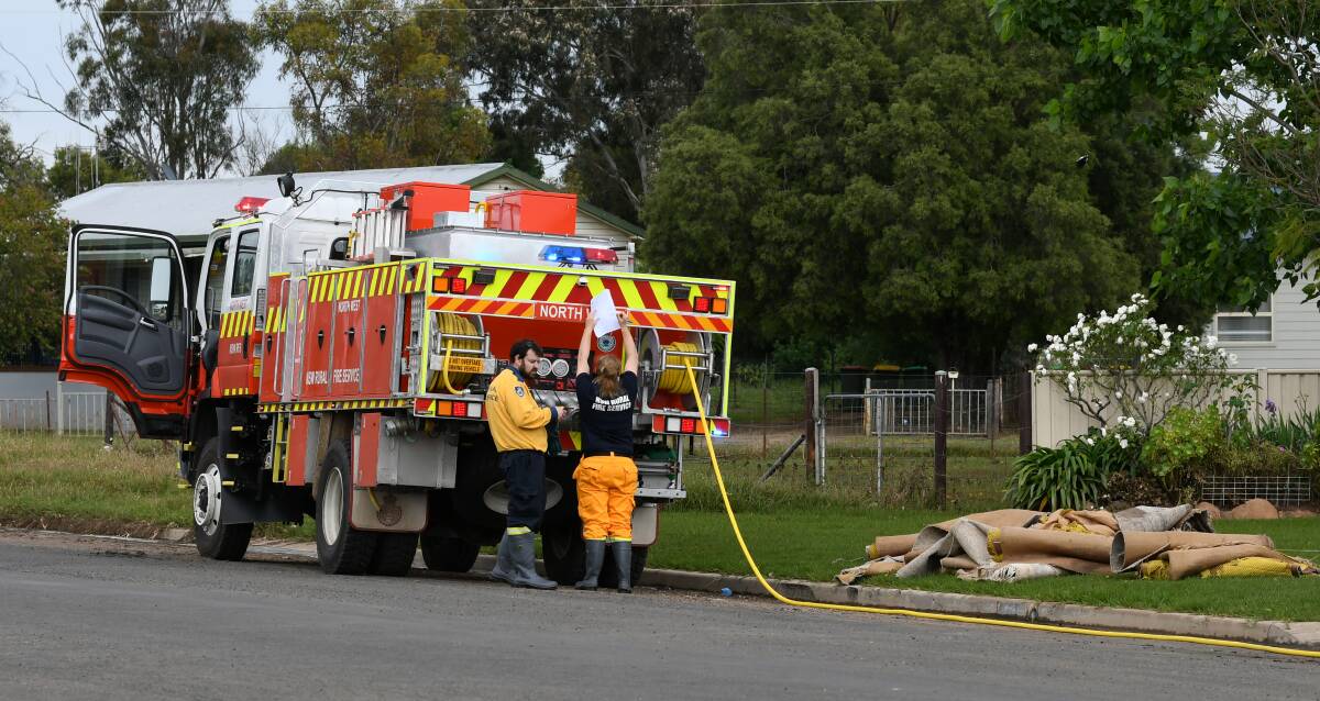 Rural Fire Service volunteers and fire trucks removing flood-damaged carpets and hosing properties out in the wake of the November 2022 floods. File picture