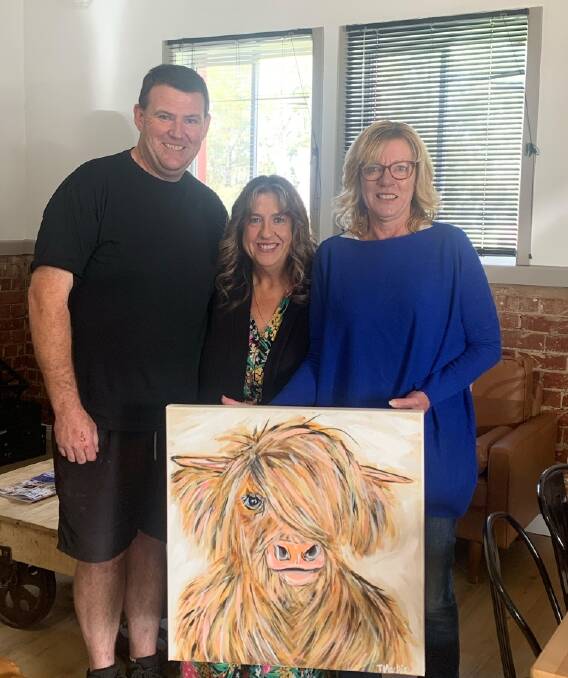 Judd McKenna with two generous ladies ... artist Tracey Mackie and purchaser Diana Frost. Picture supplied