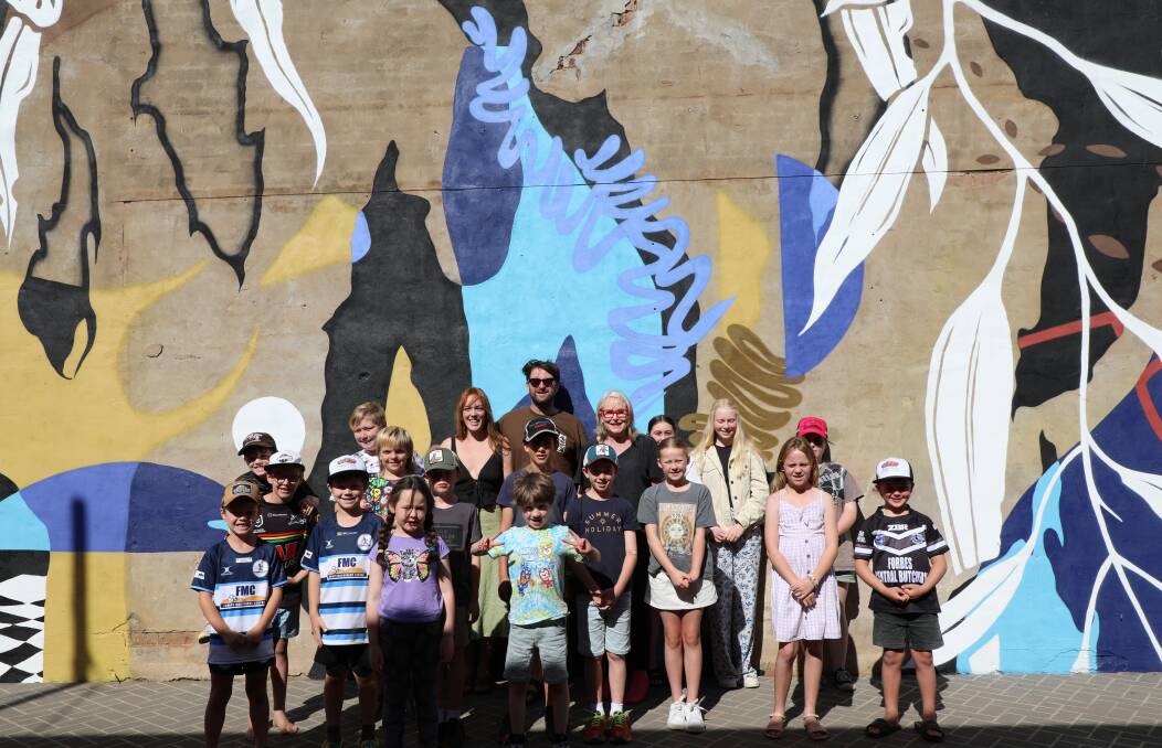 Artist Nick Stewart and Mayor Phyllis Miller with some of the young artists who helped with this mural in Hughes Lane. Picture by Forbes Shire Council
