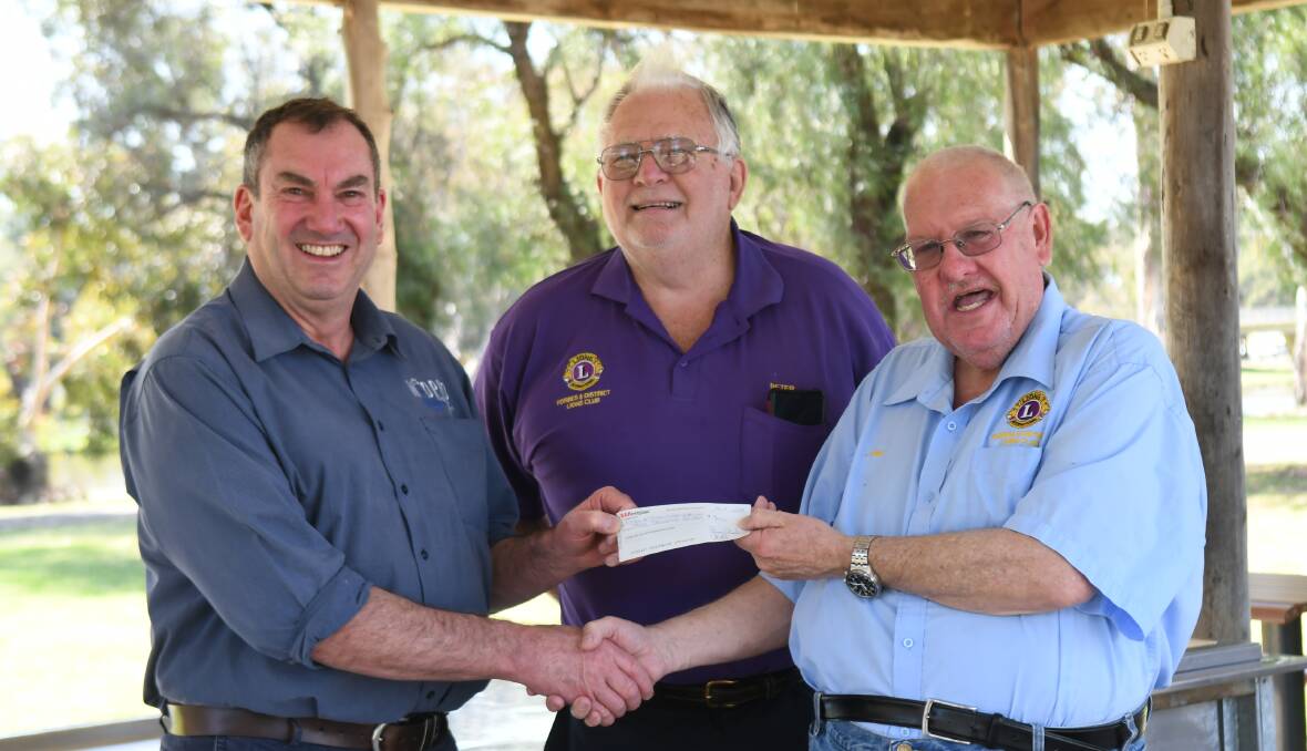 Ian 'Bart' Bartholomaeus presents a cheque with some of the Motor Show proceeds to Forbes Lions Peter Bright and Neil Lambert. 