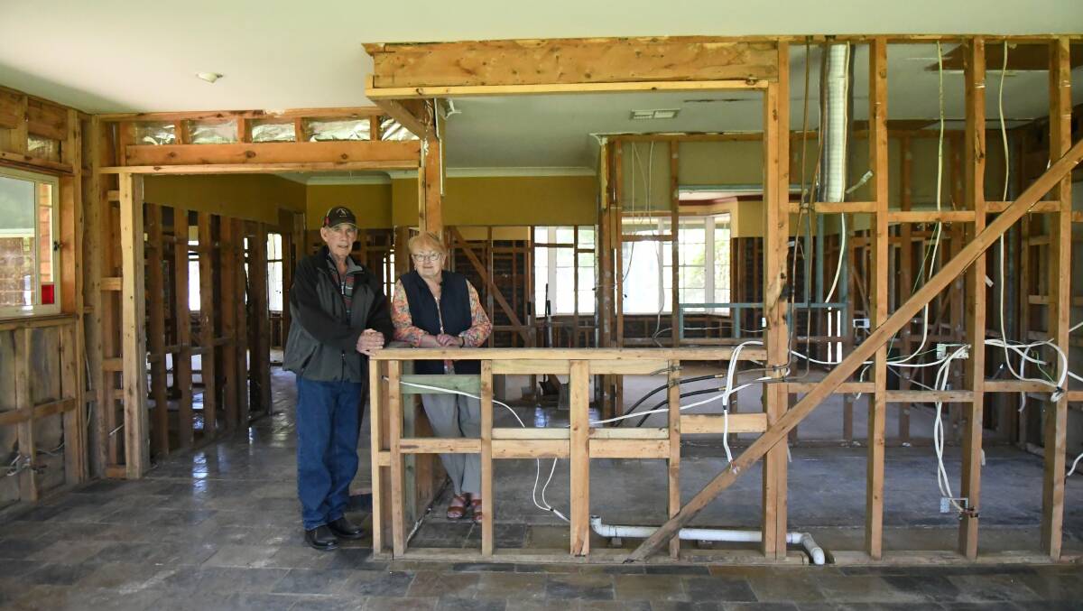 Ken and Judy Smith stand in the shell of their home, gutted after chest-high water surged through it on November 14, 2022.