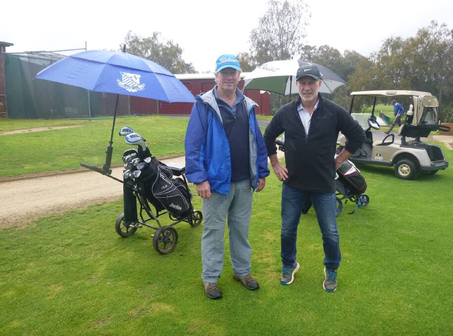 Bede Tooth and Dave Bernardi find a clear period to ready themselves for a day in the rain. Picture by Short Putt